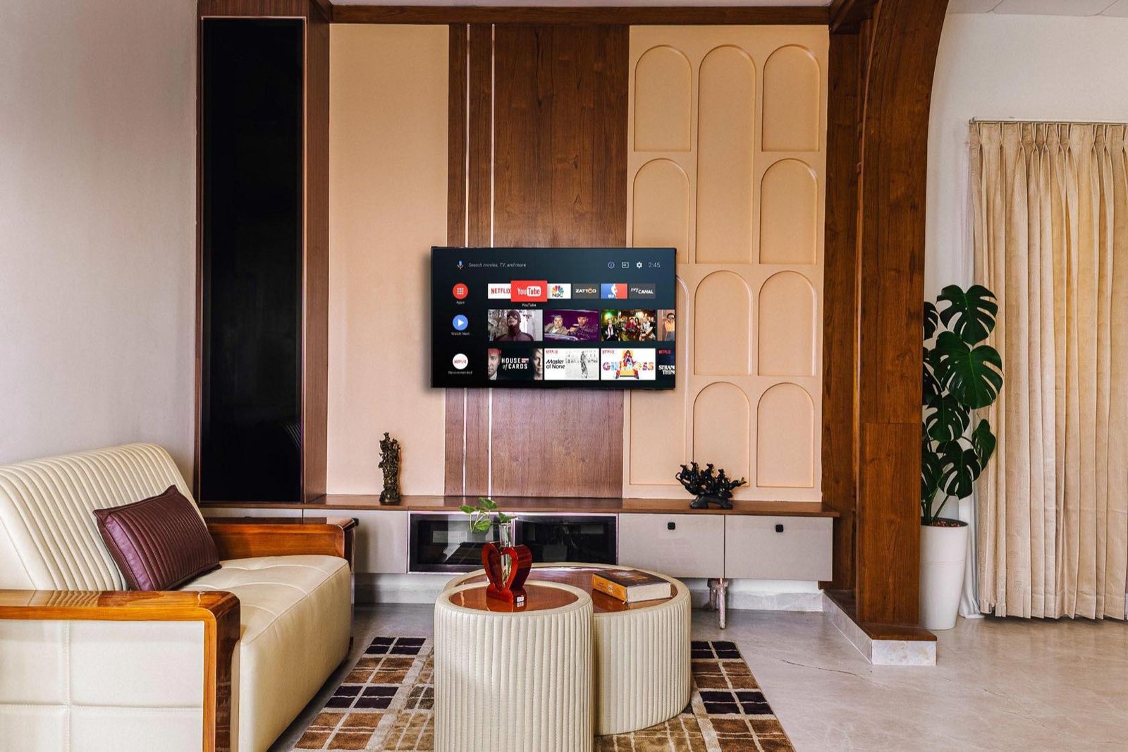 Common living space with arched panelling, sofa and media wall