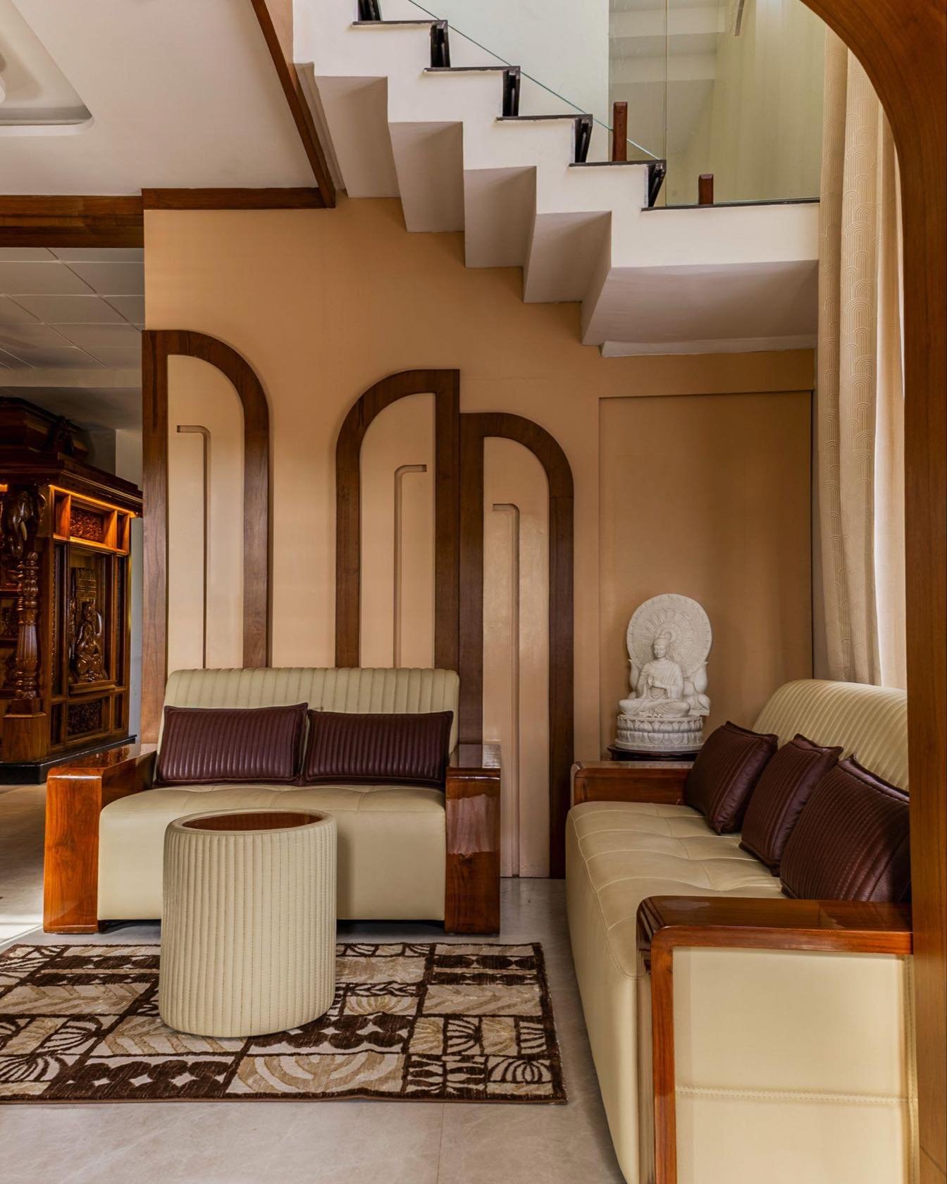 Staircase and living seating beyond arched panelling