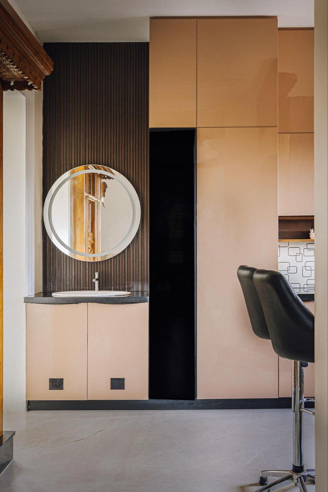 Vanity with a round mirror and fluted cabinetry
