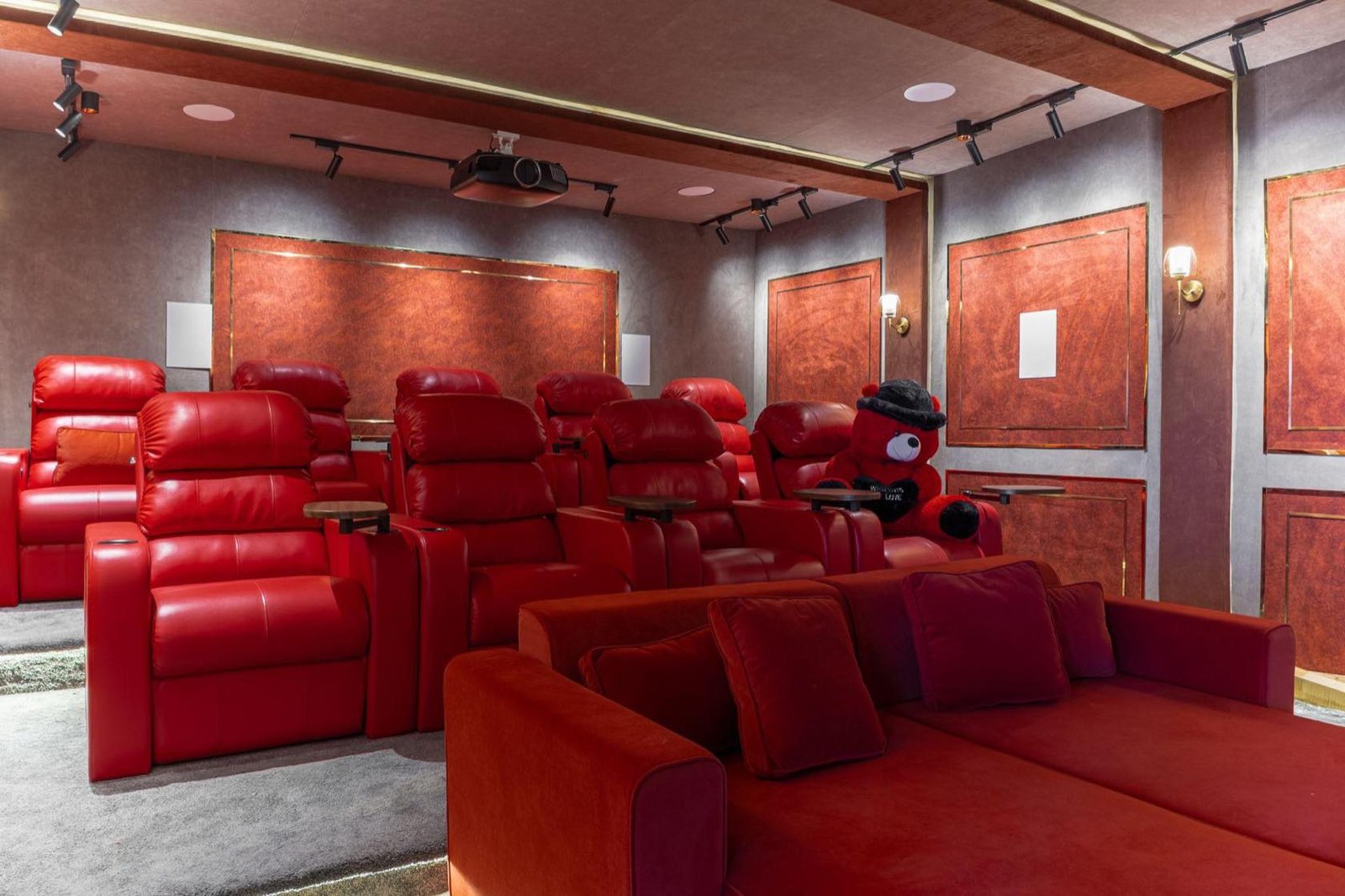 Home theatre with red recliners and acoustic wall panelling