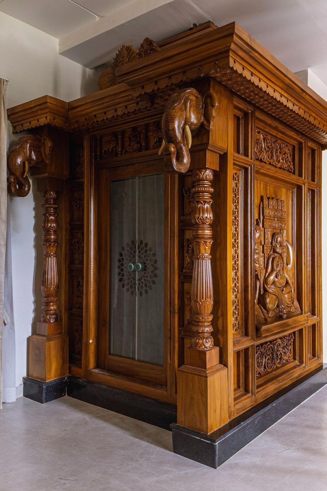 Hand-carved teak mandir with elephant brackets and sculpted deities