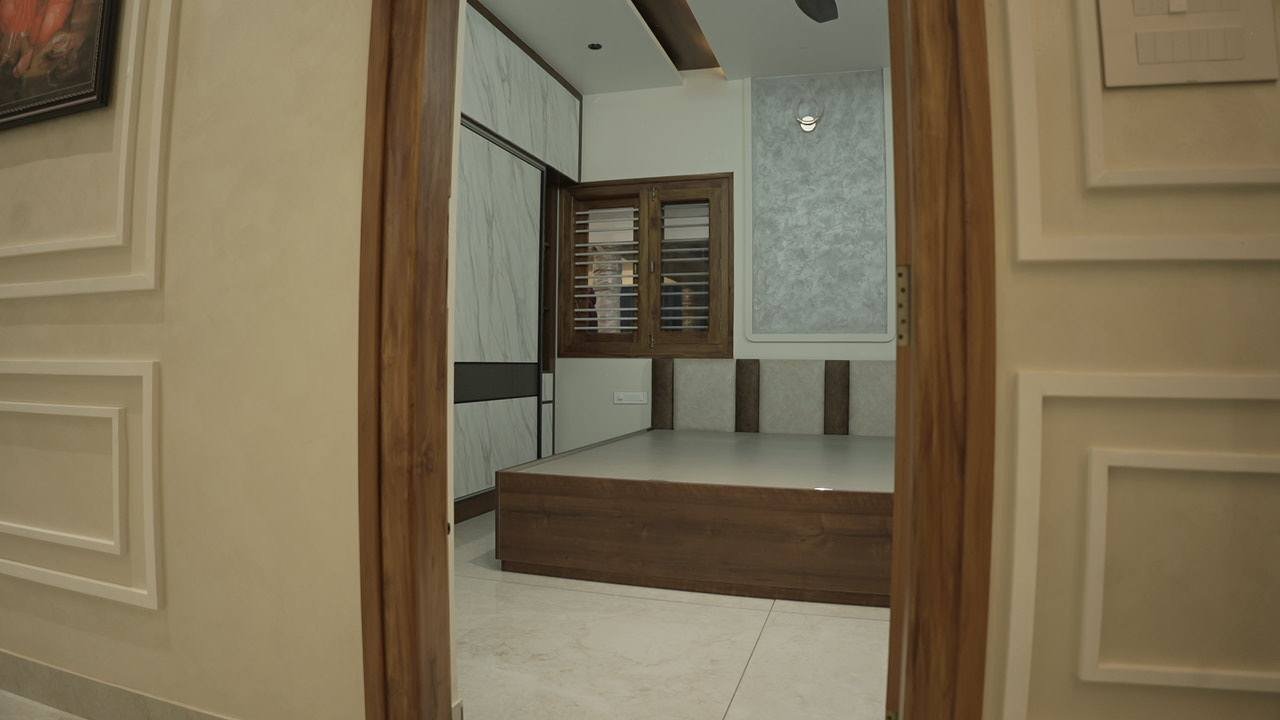 Parents' bedroom seen through a timber doorway, with a marble-look wardrobe and timber windows